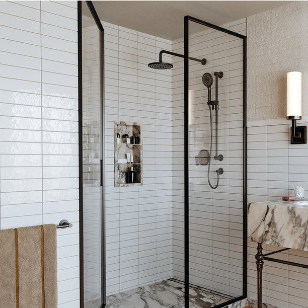 A Riobel ARCA bath collection brochure page showing a modern walk-in shower enclosure with black-framed glass panels, white subway tile walls, a marble vanity, and a mirror. Smaller inset photos appear along the bottom with descriptive text.