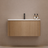 Bathroom vanity with wooden cabinet and white countertop against a beige wall.