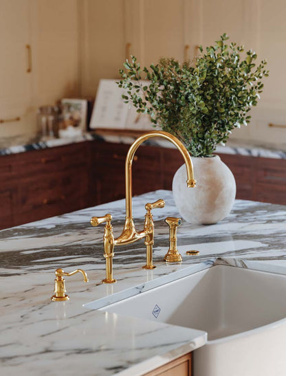Perrin & Rowe Georgian Era bridge kitchen faucet and soap dispenser in a gold-toned kitchen setting