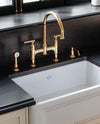 Perrin & Rowe Southbank bridge kitchen faucet with side spray and soap dispenser in a gold-toned kitchen detail