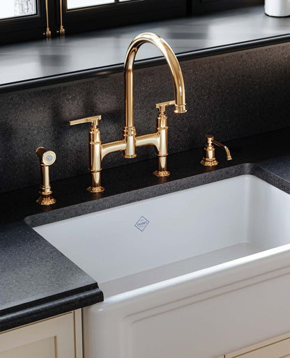 Perrin & Rowe Southbank bridge kitchen faucet with side spray and soap dispenser in a gold-toned kitchen detail